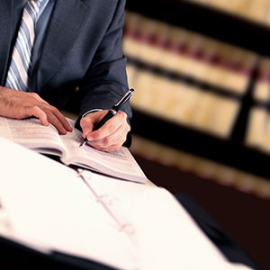 A men in suit writing on a book - Serving Immigrants