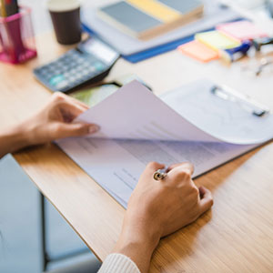 A person holding a pen over a piece of paper - Serving Immigrants