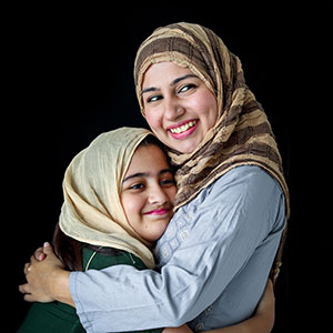 A mother and daughter embracing warmly - Serving Immigrants