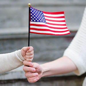 A woman holding a flag - Serving Immigrants