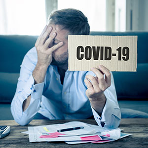 Man displaying COVID-19 sign - Serving Immigrants