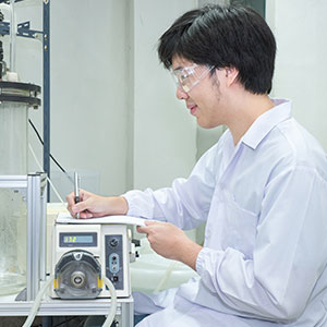 A man in a lab operating a machine - Serving Immigrants