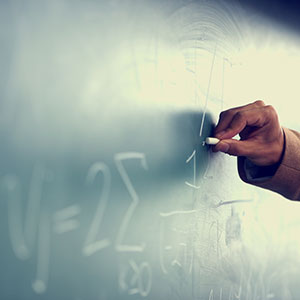 A man writing on a chalkboard - Serving Immigrants