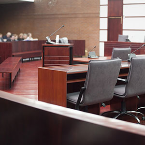 A court room with a few chairs and a microphone - Serving Immigrants