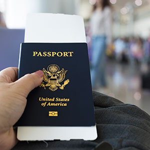 A hand holding a passport - Serving Immigrants