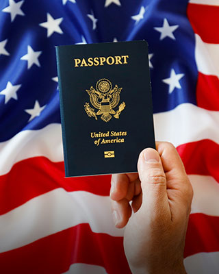 Person holding American passport with flag on background - Serving Immigrants