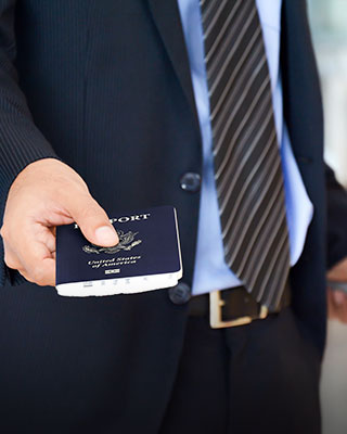 A man holding a passport, prepared for his journey abroad - Serving Immigrants