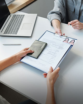 Person holding a clipboard with a document - Serving Immigrants